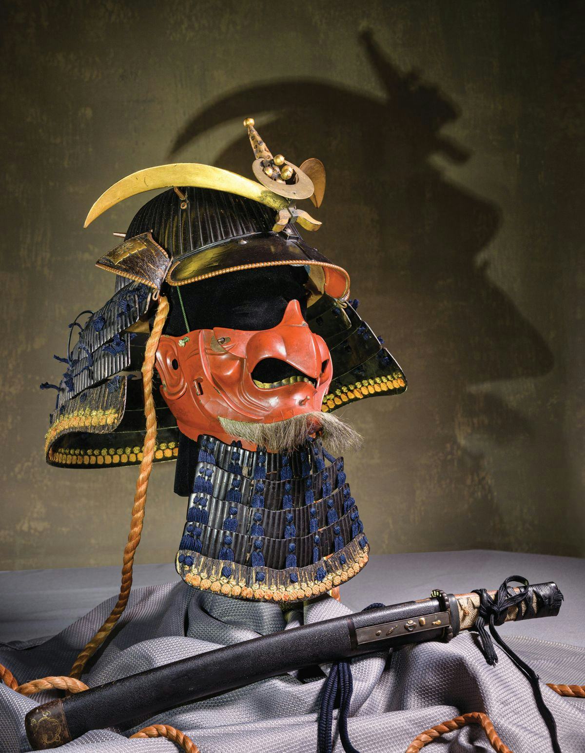 Riveted helmet, mask-like facial armor and a sheathed short sword, known as a wakizashi.