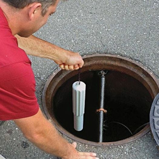man inserting the Eastech Flow Control iTracker sensor into a manhole