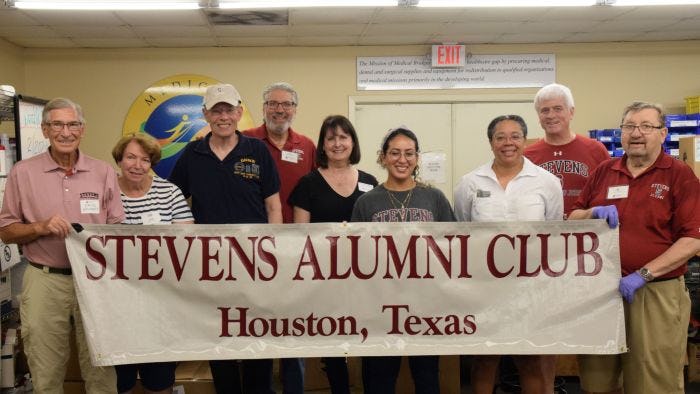 Houston Alumni Club members gathered with banner