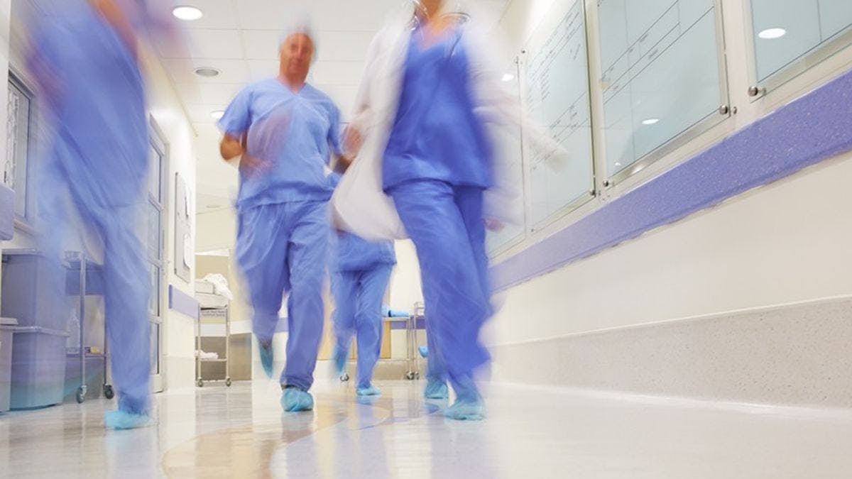 A medical team rushes through the corridors of a busy hospital.