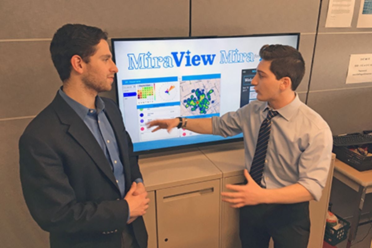 Two students present their business concept in a conference room.