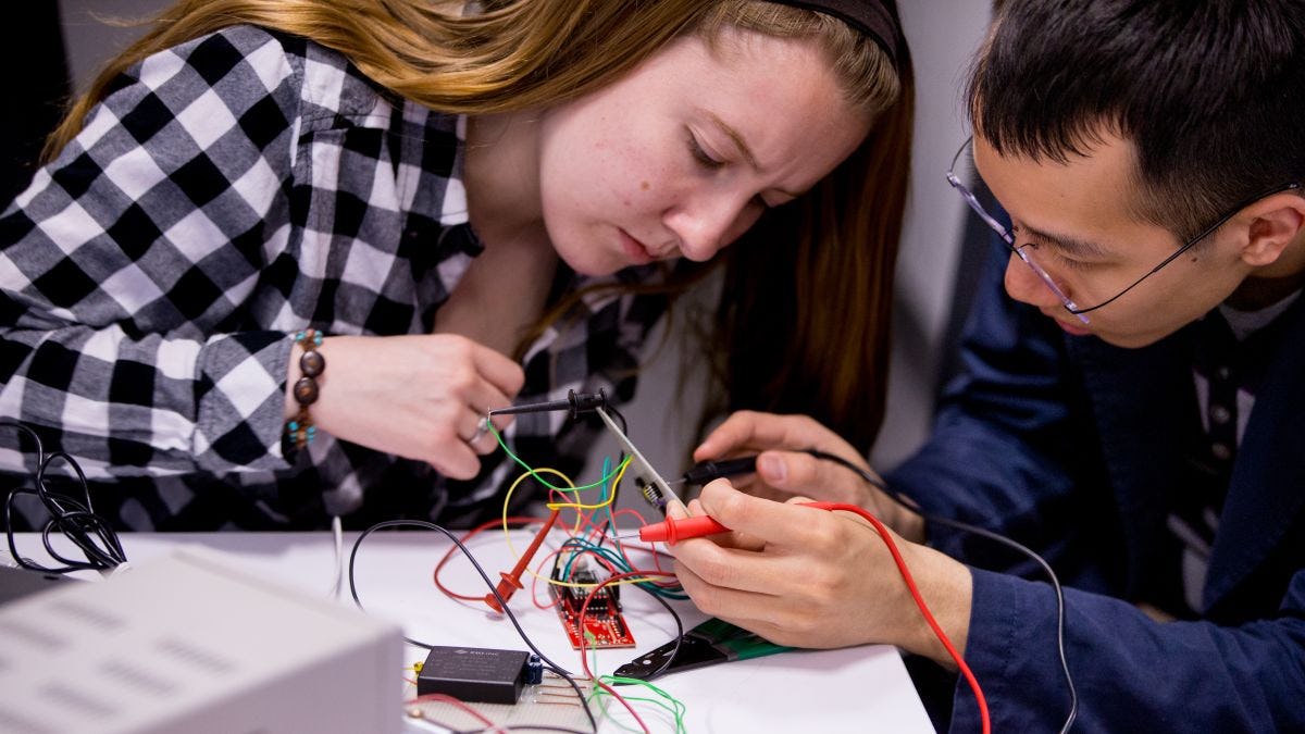 Two students working on circuit board