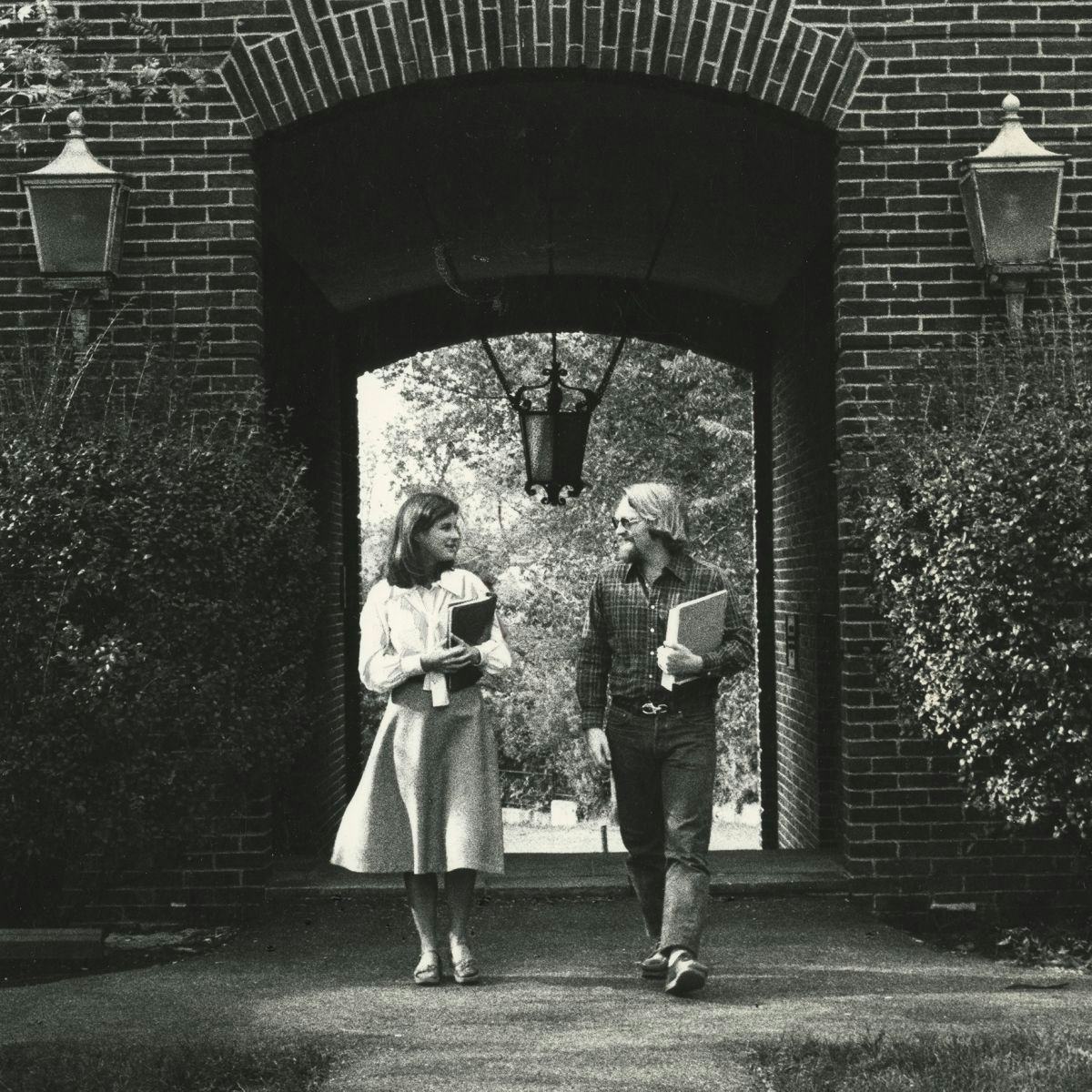 Photo from the 1980s of two students walking on campus.