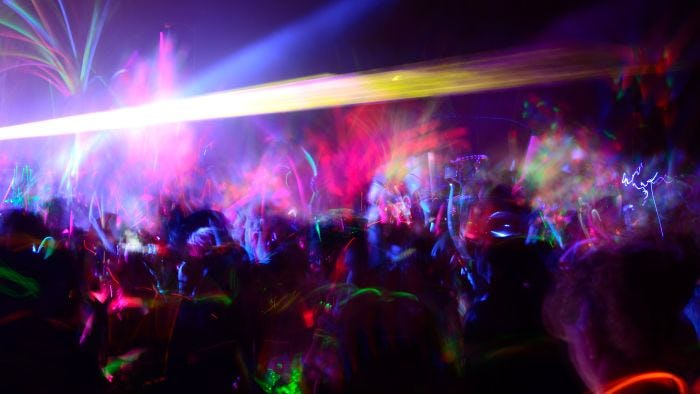 A stock visual of a dance party with glow sticks