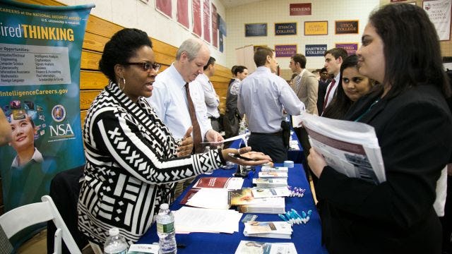 Women standing at a booth with brochures and pens