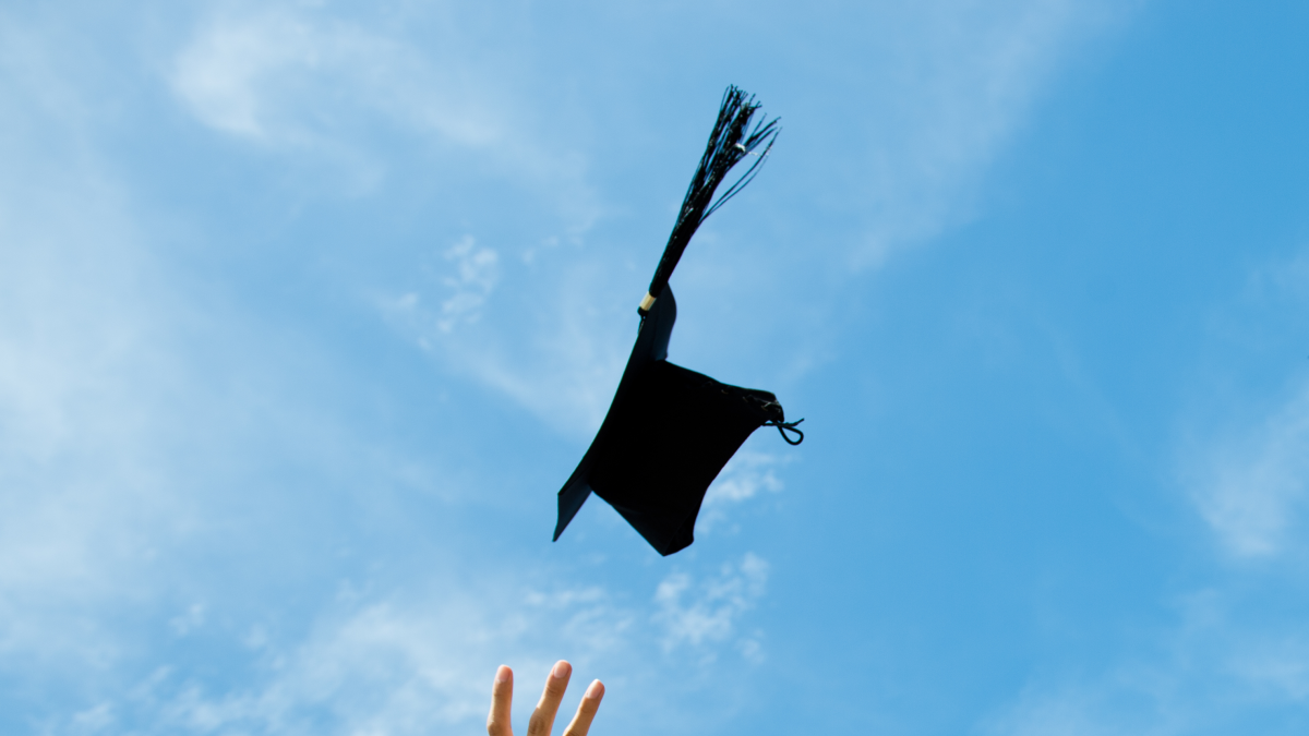 Photo of arm throwing graduation cap in the air