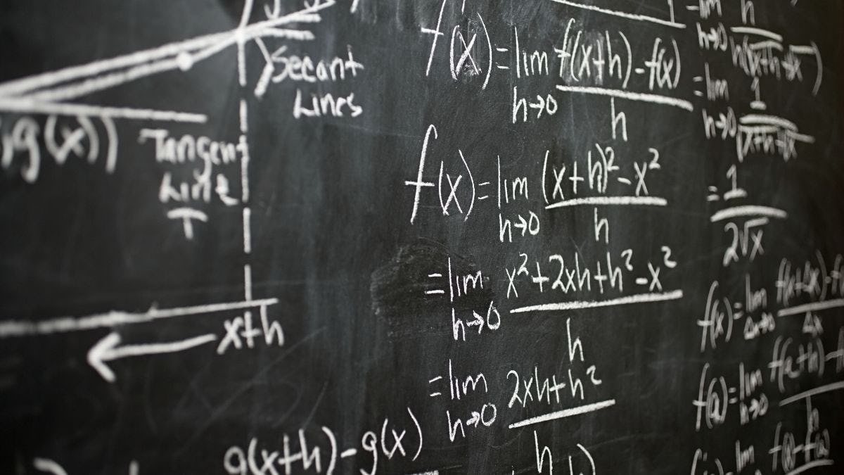 Calculus equations written on a blackboard in chalk. 