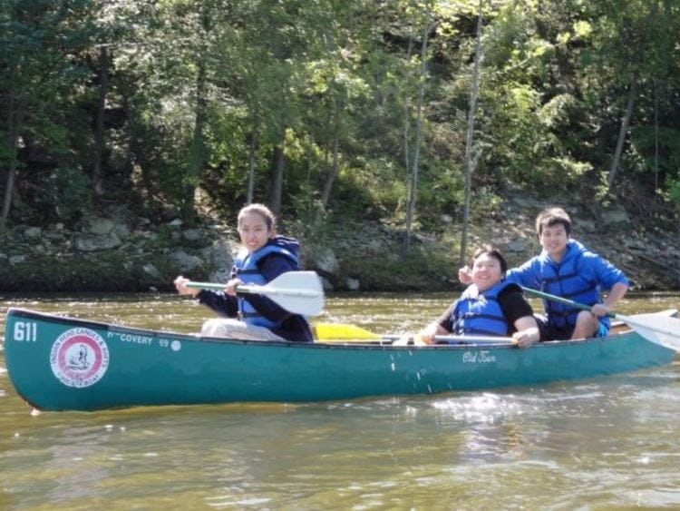 3 individuals in a canoe 