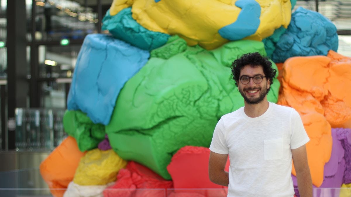 Photo of entrepreneur and data scientist Raphael Presberg M.S. '18 in front of a colorful sculpture
