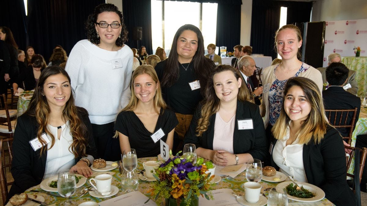 Five Stevens students gathered at a table in Bissinger Hall where luncheon was held