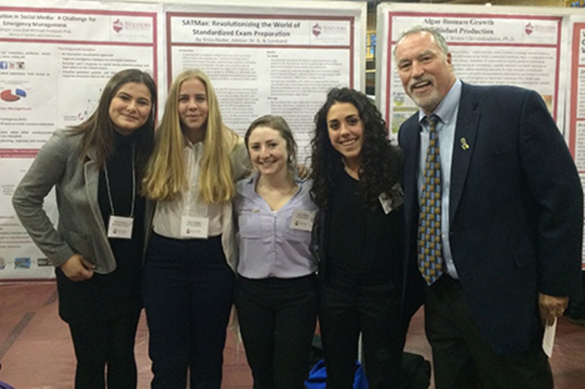 Stevens students at a research poster session with Dr. Don Lombardi.