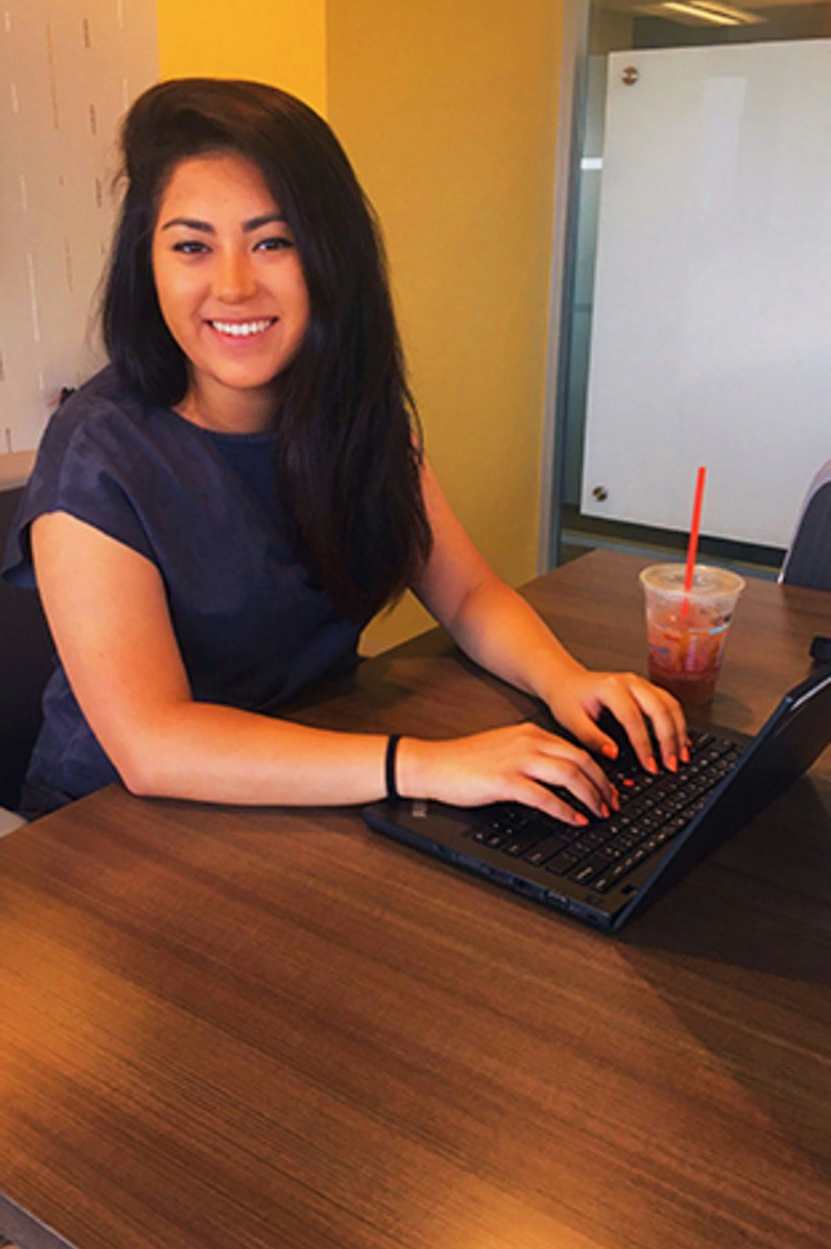 Jane Castro sits at a laptop in a conference room at PwC's offices in Philadelphia.