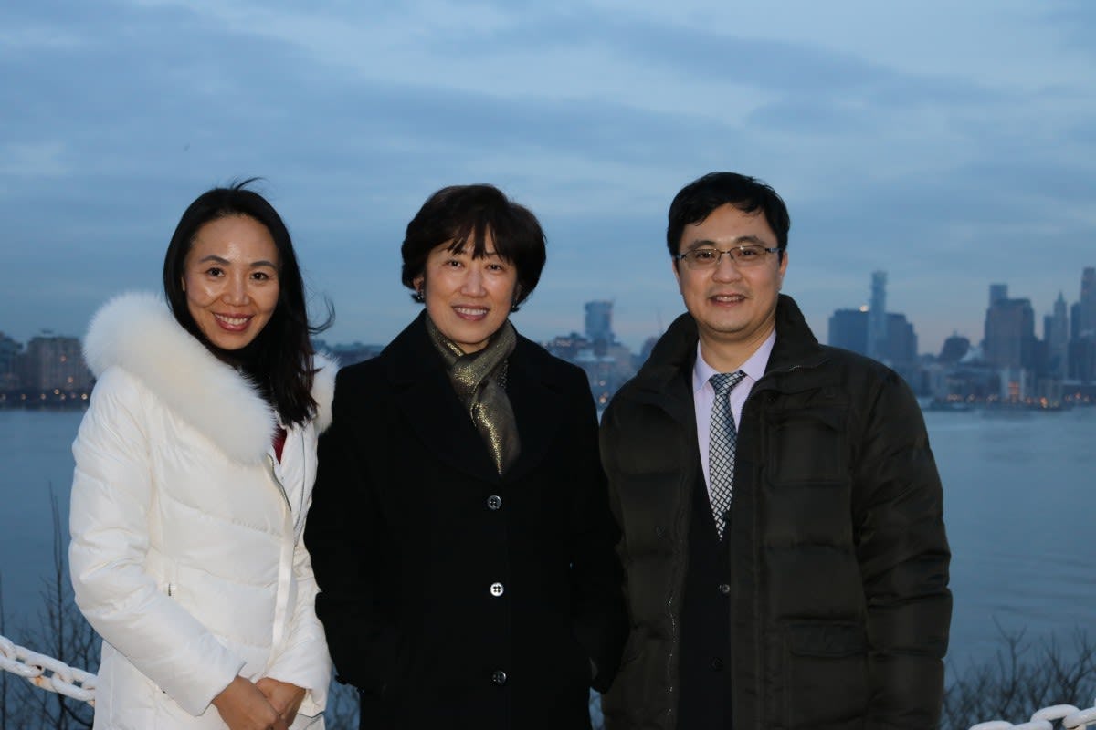 Annie Song, Dean Zu and Lin Zhang on campus, with downtown Manhattan in the background.