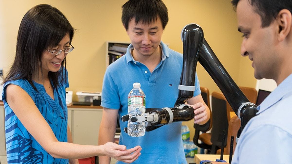 Yi Guo and Ph.D. students Chao Jiang and Muhammad Fahad work with a robotic arm. CREDIT: Kat Kendon