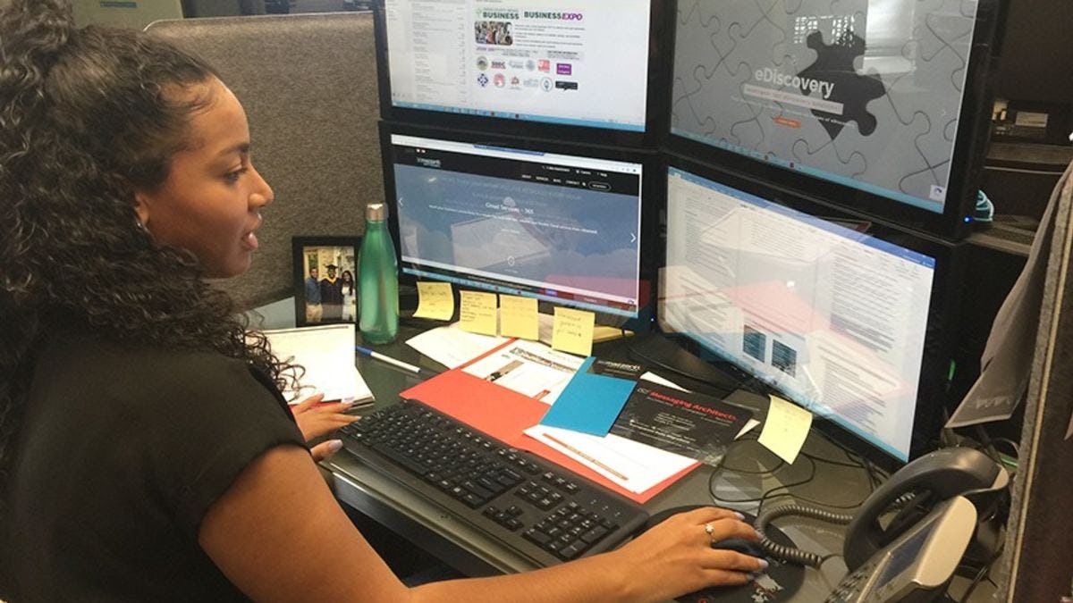 Andrea Gamboa keeping track of data on four computer screens at eMazzanti Technologies.
