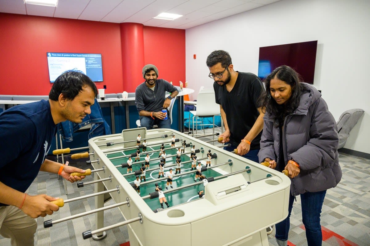 students playing in game room at new university center