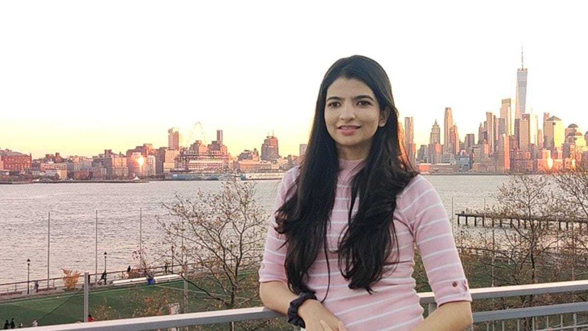 Aayushi Gandhi with the lower Manhattan skyline in the background.