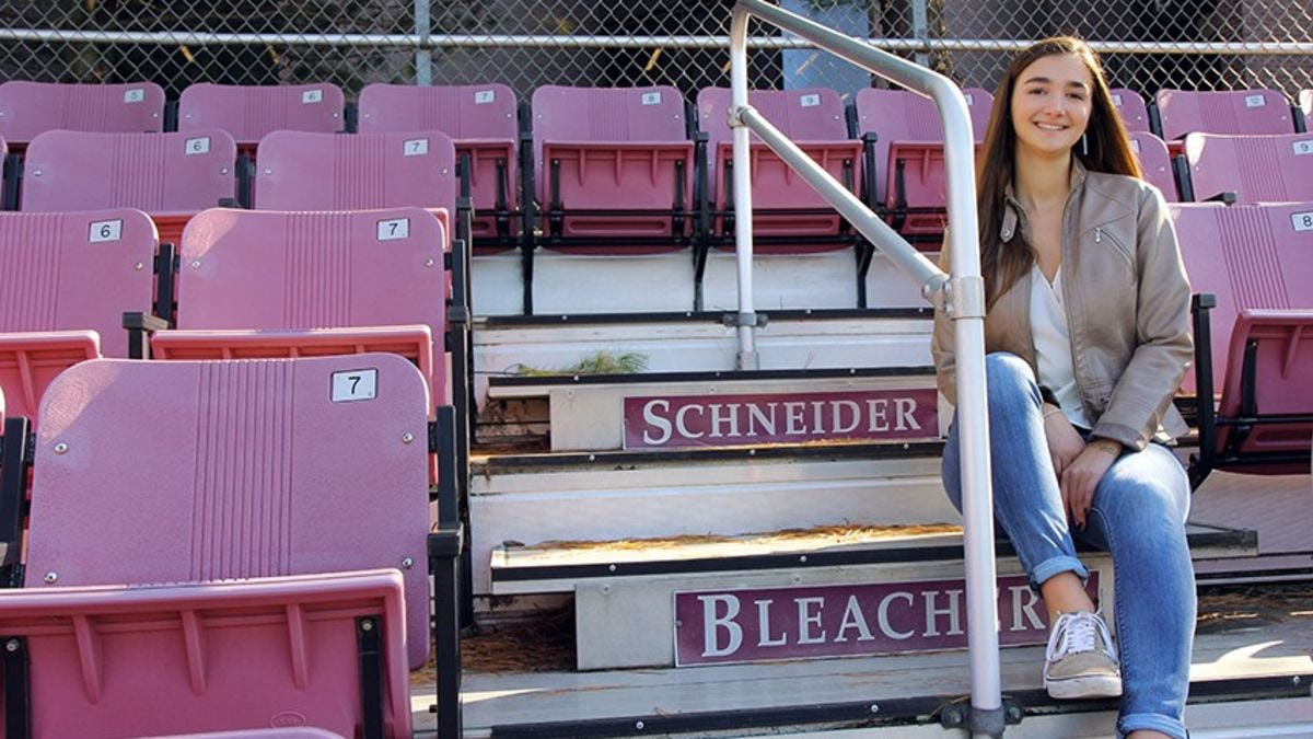 Undergraduate business student Zenya Koprowski sitting on the Schneider Bleachers.