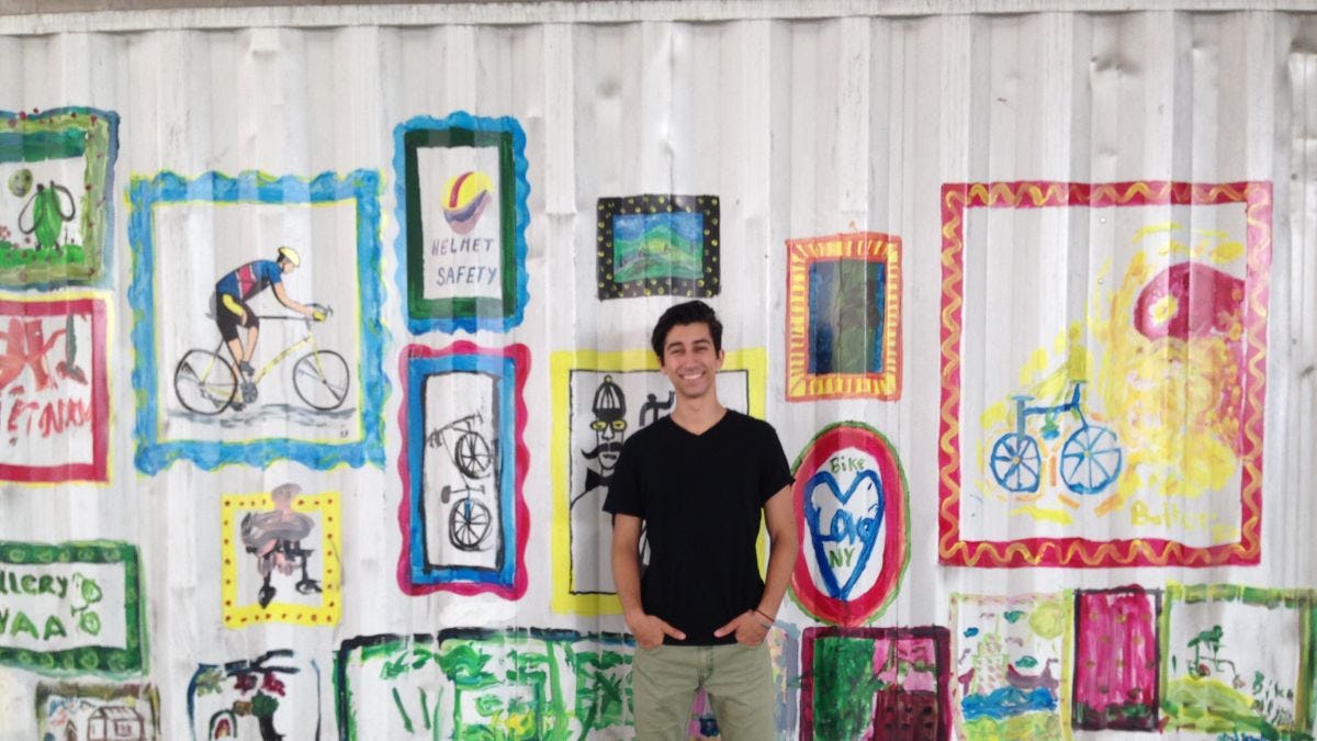 Ryan Bertani standing in front of a mural of bike motifs