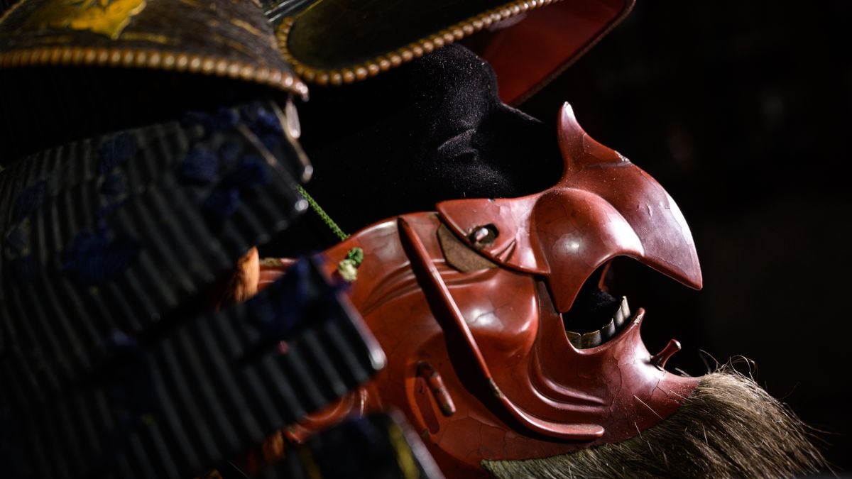 A close-up of the iron samurai helmet and red lacquered face mask