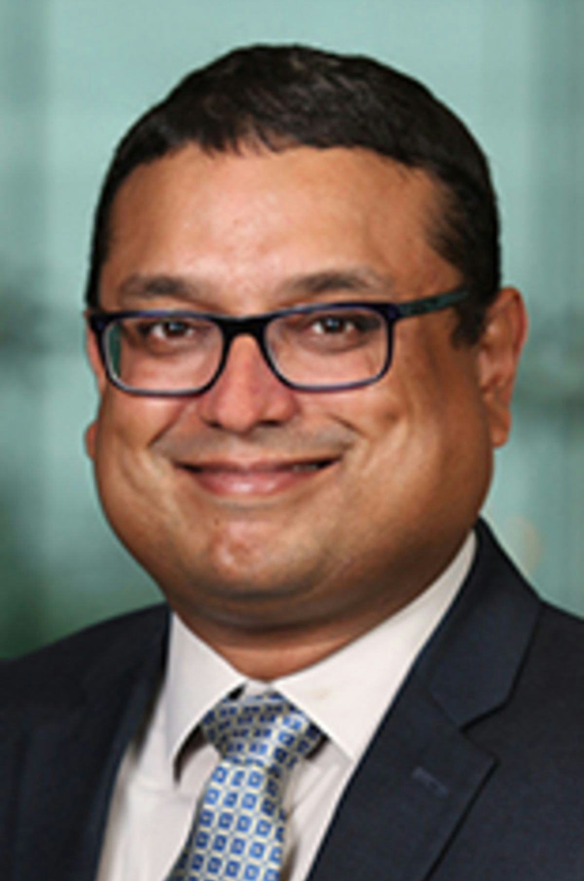 Headshot of Dr. Gaurav Sabnis with the New York City skyline visible in the background.