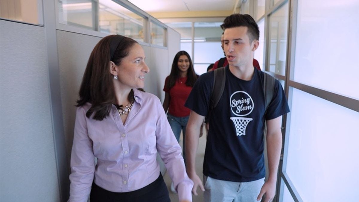 A female professor and male student walk through a corridor together in the Babbio building on the Stevens campus.