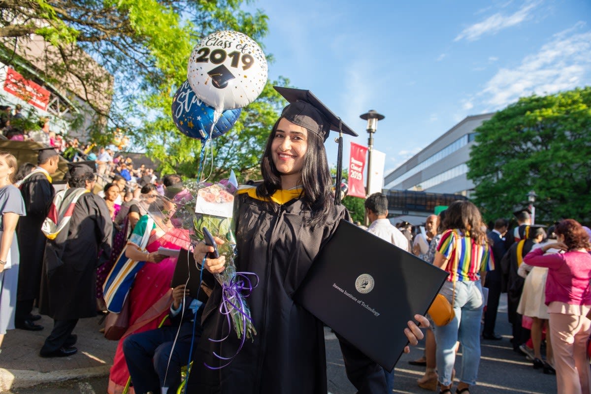 A member of the Stevens  Graduate Class of 2019 proudly displays her diploma