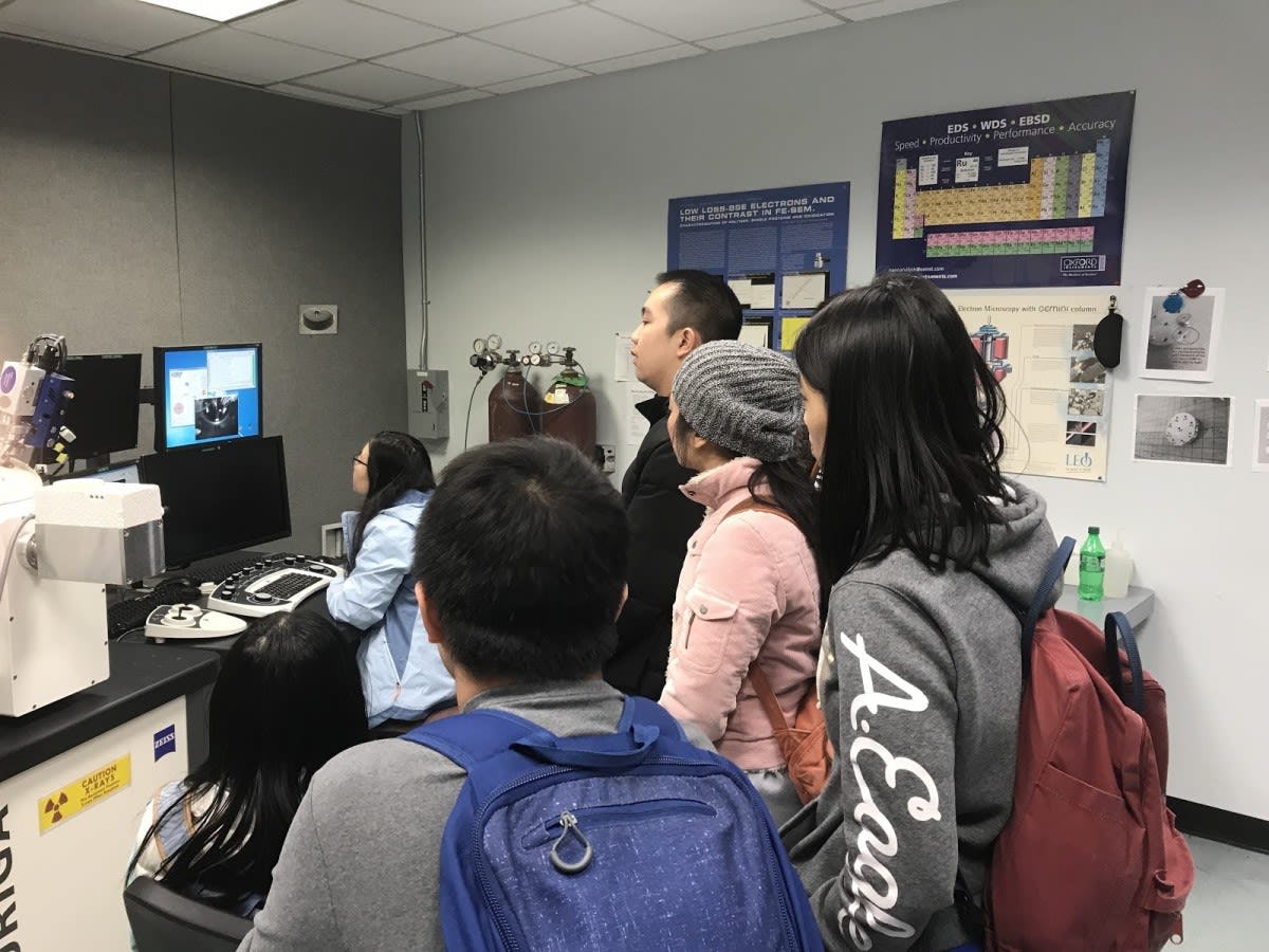 Chemical Engineering PhD student Xiaoqing Kong showing the group how to use a scanning electron microscope to look at samples of organic semiconductors under high magnification.