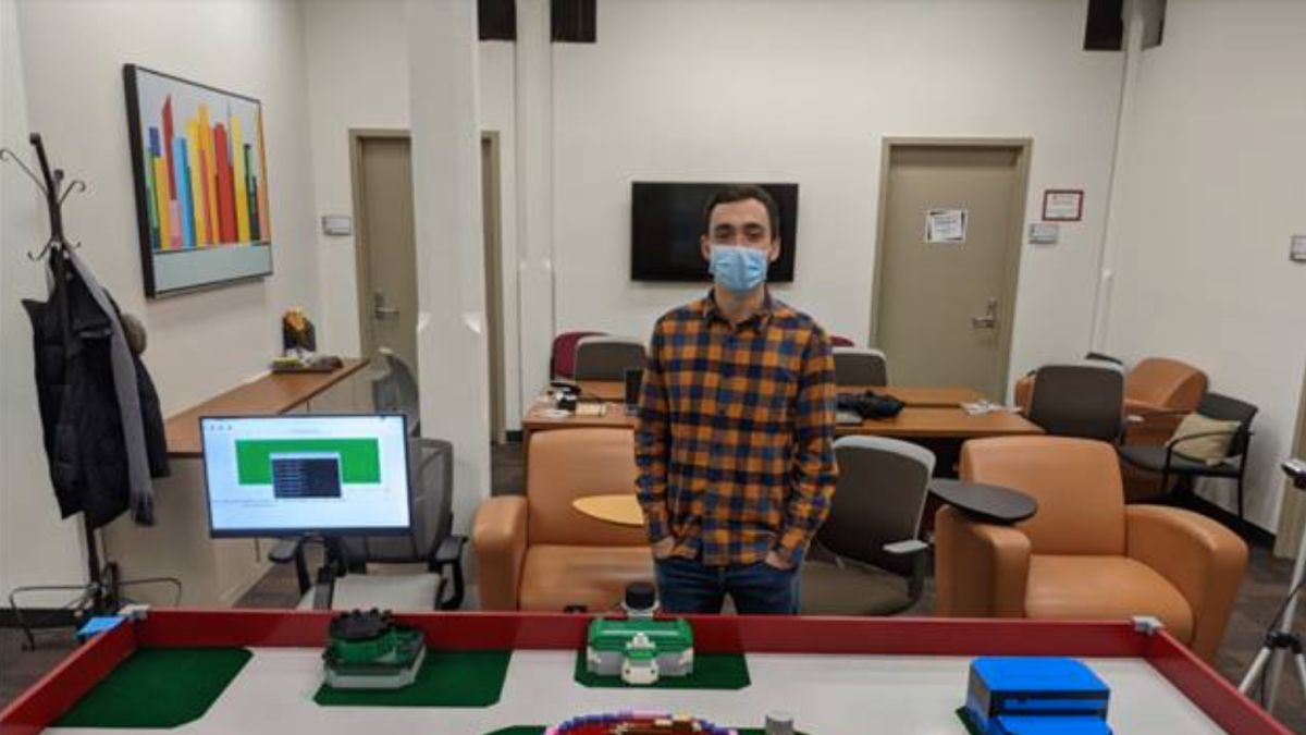 photo of student in front of Stevens campus simulation