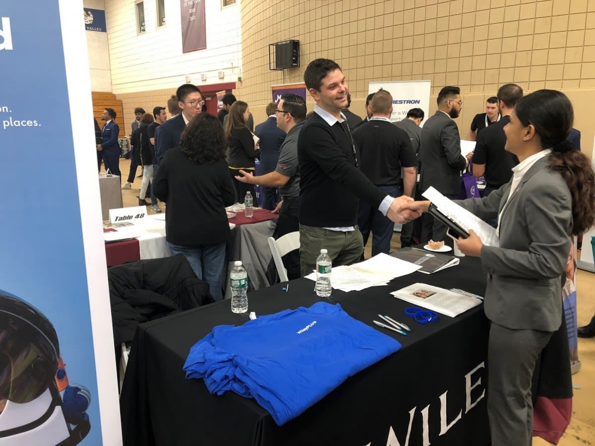 Recruiter from Wiley shaking hands with Stevens student