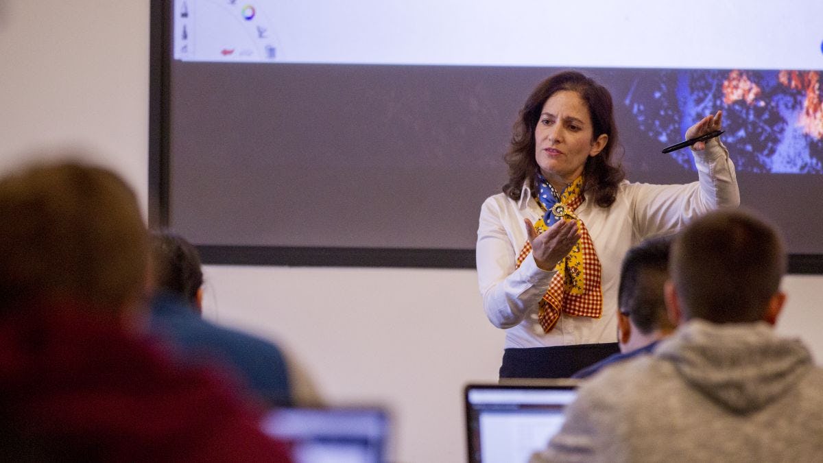 Dr. Joelle Saad-Lessler teaching a class at Stevens in front of a digital screen.