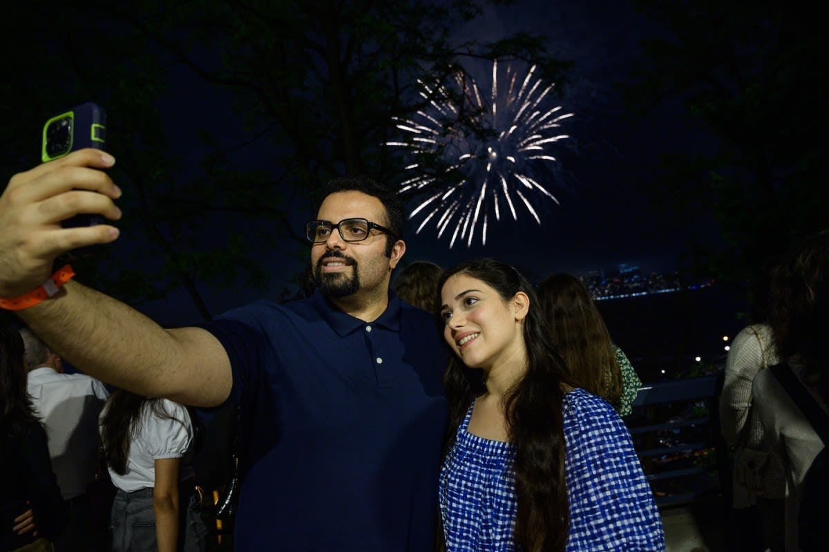 attendees taking selfie with fireworks