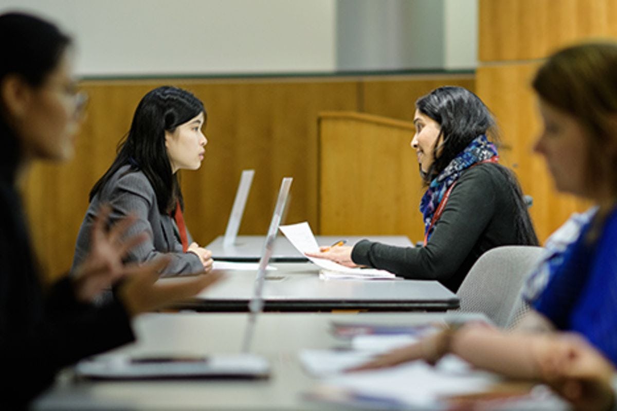 A recruiter and Stevens student speak at a conference table.