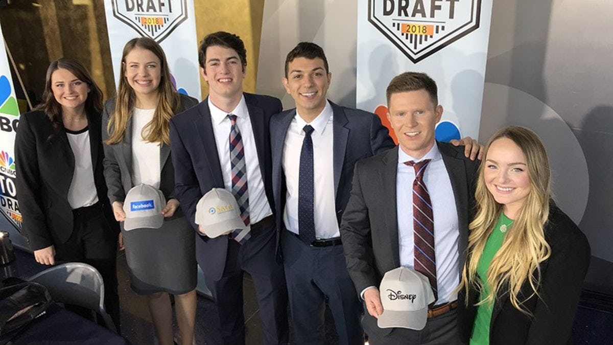 The six Stevens students holding the baseball caps with the company logos of their picks.